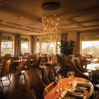 Wide-angle of a restaurant with polished wood floor and modern chandelier